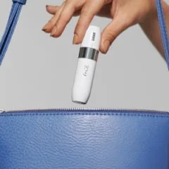 Braun Mini-Haarentferner wird in eine blaue Handtasche gelegt, um die kompakte Größe und Portabilität hervorzuheben.