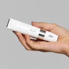 Braun Body Haarentferner in einer Hand gehalten, Fokus auf dem BODY Schriftzug auf dem Gerät.